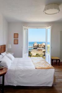 a bedroom with a large bed with a view of the ocean at Santina in Castellammare del Golfo