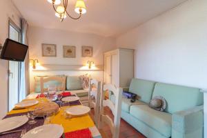- un salon avec une table et un canapé dans l'établissement Résidence Pierre & Vacances Eden Parc, à Saint-Tropez