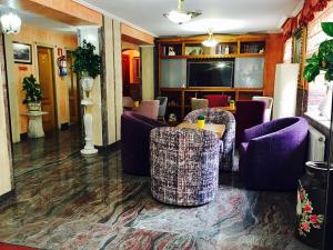 a lobby with purple chairs and a table at Hotel Maria del Mar in Noja