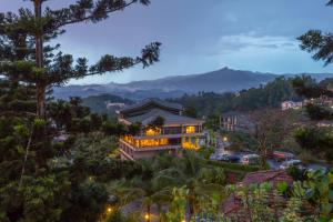 una casa en una colina con montañas al fondo en Kandy The Tourmaline, en Kandy