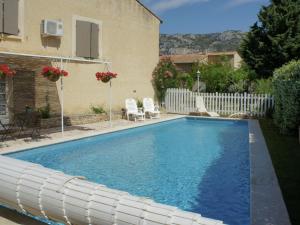 a swimming pool in front of a house at Charming holiday cottage with large private pool in Robion en Luberon