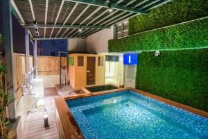 a large swimming pool with a green wall at Momizi Business Hotel in Hanoi