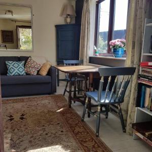 a living room with a table and chairs and a couch at Dilkara Apartment Glastonbury in Glastonbury