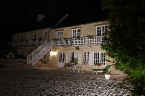 a building with a staircase in front of it at night at Le Clos Saint Jean in Sainte-Honorine-des-Pertes