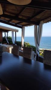 - une table avec des chaises et une vue sur l'océan dans l'établissement Casa De S'Arca, à Torre Dei Corsari