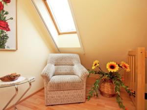 ein Zimmer mit einem Stuhl und einer Vase aus Blumen in der Unterkunft Holiday home with terrace in Schmogrow Fehrow in Schmogrow