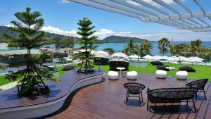 un patio con mesas y sillas y vistas al agua en The Bloc Hotel - SHA Extra Plus en Patong