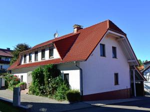 ein weißes Haus mit einem orangefarbenen Dach in der Unterkunft Apartment in Eimelrod with Panoramic Views in Willingen