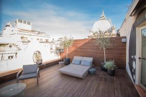 - un balcon avec deux chaises et un banc dans un bâtiment dans l'établissement Petit Palace Museum, à Barcelone