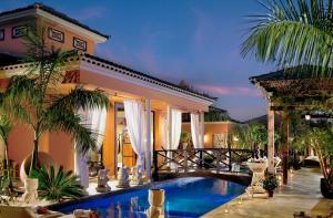 a house with a swimming pool in front of a house at Royal Garden Villas, Luxury Hotel in Adeje