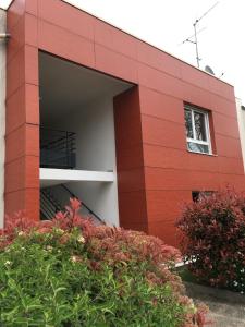 a red brick building with a garage at Appart'Hôtel - Chateaubriant in Châteaubriant +2 photos