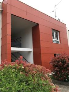 un bâtiment en briques rouges avec un garage dans l'établissement Appart'Hôtel - Chateaubriant, à Châteaubriant