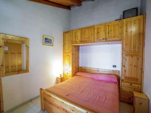 Schlafzimmer mit einem Holzbett und Holzschränken in der Unterkunft Belvilla by OYO Chalet Antey Trilo in Antey-Saint-André