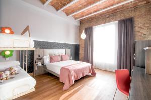 a bedroom with a white bed and a red chair at Petit Palace Museum in Barcelona