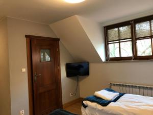 a bedroom with a bed and a flat screen tv at Dom Gościnny Browarna 4 in Kazimierz Dolny