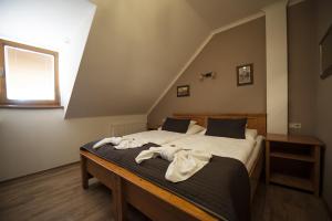 a bedroom with a bed with towels on it at Penzion Valtice in Valtice