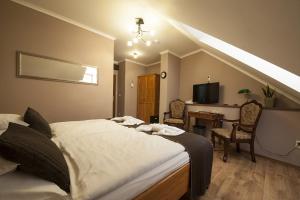 a bedroom with a bed and a desk with a television at Penzion Valtice in Valtice