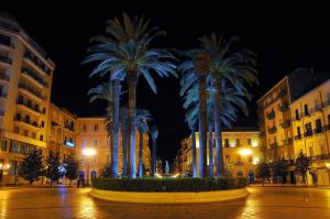 a group of palm trees in a city at night at Room n.22 in Taranto