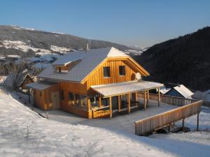 ein Holzhaus im Schnee mit Dach in der Unterkunft Chalet in Styria near the ski area in Stadl an der Mur