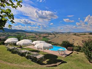 un grupo de sombrillas y sillas junto a una piscina en Serene Holiday Home in Piticchio with pool and scenic views en Arcevia