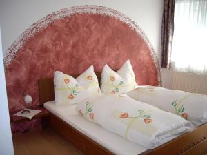 a bed with a red headboard and white pillows at Gasthof in der Exlau in Neuhaus