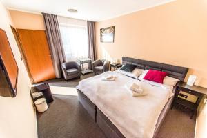 una camera d'albergo con un grande letto e una sedia di Penzion Harley Pub a Otrokovice