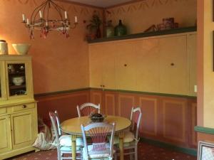 a kitchen with a table and chairs and a cabinet at Château Luxury Stay Montbrun in Montbrun-les-Bains