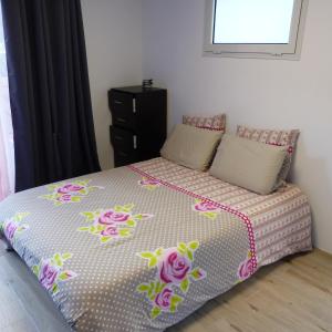 Un dormitorio con una cama con flores rosas. en Le Bas de Cilaos, en Cilaos