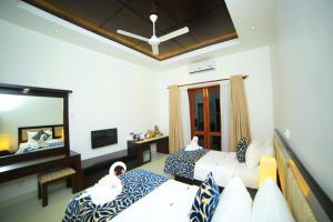 una camera d'albergo con due letti e uno specchio di Ruins Chaaya Hotel a Polonnaruwa