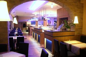 ein Restaurant mit Tischen und Stühlen und einer Bar in der Unterkunft Hotel Seeterrassen in Laboe