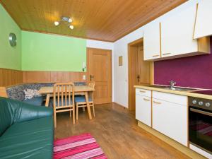 a kitchen and living room with a table and a couch at Plush Apartment in Altenmarkt im Pongau near Ski Area in Altenmarkt im Pongau
