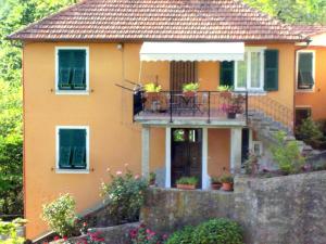 una casa gialla con balcone e portico di Belvilla by OYO Casa Marcellini a Sesta Godano