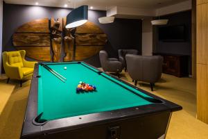 a billiard room with a pool table and a barrel at Hotel Wodnik in Giżycko