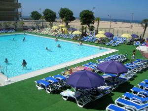 an overhead view of a pool with chairs and umbrellas at Apartamento Casino Praia in Figueira da Foz