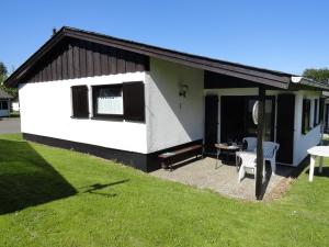 uma pequena casa branca com uma mesa e uma cadeira em Cosy holiday home in Willingen Usseln with terrace em Willingen