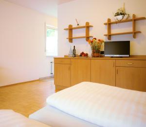 コブレンツにあるBoardinghaus Hähnのベッドルーム(ベッド1台、テレビ、棚付)