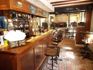 a bar in a pub with wooden furniture and chairs at The Poachers Inn in Dorchester