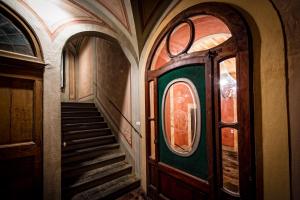 a hallway with a door and stairs in a building at Palazzo Petrella in Cortona