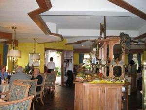 a restaurant with people sitting at tables in a room at Hotel-Restaurant Pfeffermühle in Dörverden