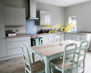 a kitchen with a wooden table and chairs in a kitchen at Spa Apartments in Harrogate