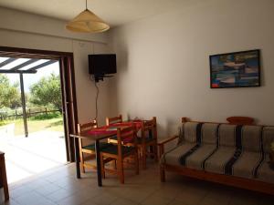 een woonkamer met een tafel en stoelen en een televisie bij Bayview Apartments in Agios Nikolaos
