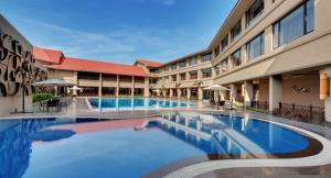 una gran piscina frente a un edificio en Iscon The Fern Resort & Spa, Bhavnagar en Bhavnagar
