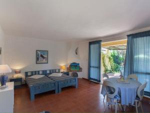 a bedroom with a bed and a table and chairs at Bright Home in Carg se Corse du Sud with Barbecue in Cargèse