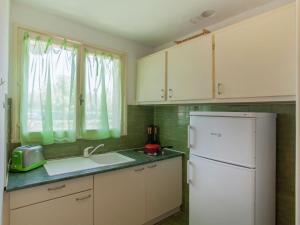 a kitchen with white cabinets and a white refrigerator at Romantic Retreat in Cargèse in Cargèse