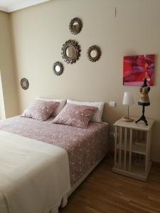 a bedroom with a bed and two mirrors on the wall at 18 Torres El Pilar in Zaragoza