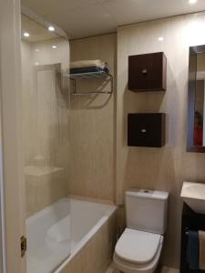 a bathroom with a toilet and a tub and a sink at 18 Torres El Pilar in Zaragoza