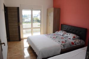 a bedroom with a bed and a large window at Apartments Flamida in Ulcinj