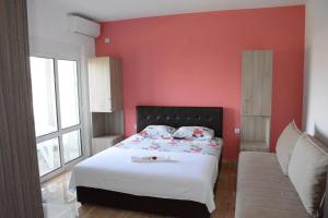a bedroom with a bed with a red wall at Apartments Flamida in Ulcinj