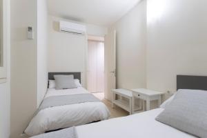 um quarto com 2 camas e uma secretária. em Bravissimo Cort Reial-1A em Girona