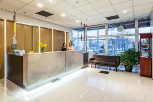 two women standing at a counter in a lobby at Hotel Wodnik in Giżycko